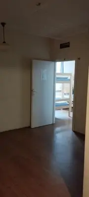 an empty room with a white door and a wooden floor at Hostel ALEX&TSA in Kraków