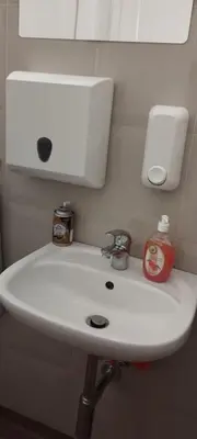 a white bathroom sink with a soap dispenser on it at Hostel ALEX&TSA in Kraków