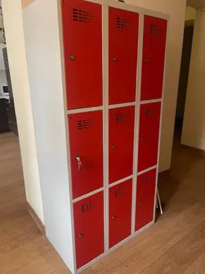 a row of red lockers in a room at Hostel ALEX&TSA in Kraków