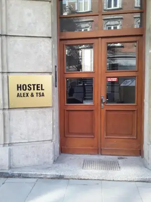 a wooden door of a building with a sign on it at Hostel ALEX&TSA in Kraków