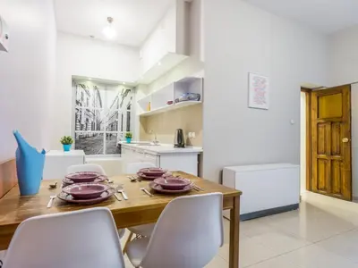 a kitchen and dining room with a wooden table and chairs at Apartamenty Idylla in Kraków