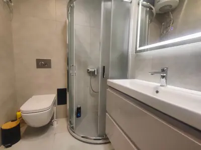 a bathroom with a shower and a toilet and a sink at Apartamenty Idylla in Kraków
