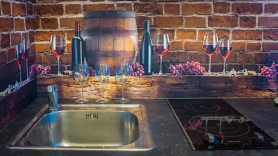 a kitchen counter with a sink and wine glasses at Apartamenty Idylla in Kraków