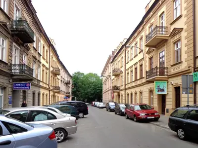 a row of cars parked on a street with buildings at Apartamenty Idylla in Kraków