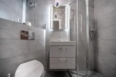 a bathroom with a toilet and a sink and a shower at Apartamenty Idylla in Kraków