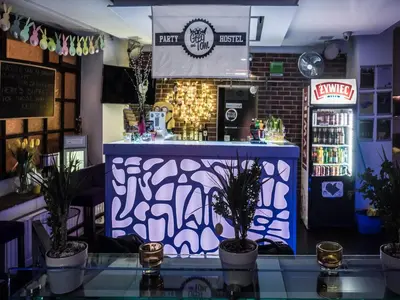 a bar with a blue counter with potted plants at Greg&Tom Party Hostel in Kraków