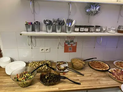 a counter with bowls of food on a table at Greg&Tom Party Hostel in Kraków