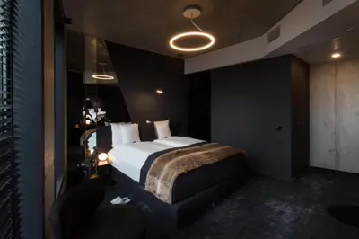 a bedroom with a bed and two chairs in it at The Loft Hotel Adults Only in Kraków