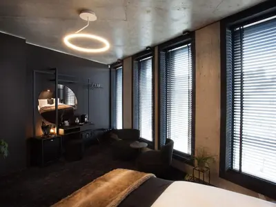 a bedroom with a bed and a mirror and windows at The Loft Hotel Adults Only in Kraków
