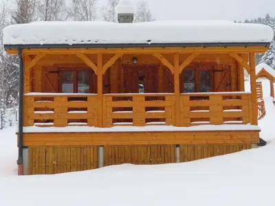 a wooden gazebo with snow on the roof at Domki Pod Jałowcem in Lachowice