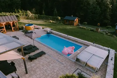 a swimming pool with a pink pig in a backyard at Domki Pod Jałowcem in Lachowice