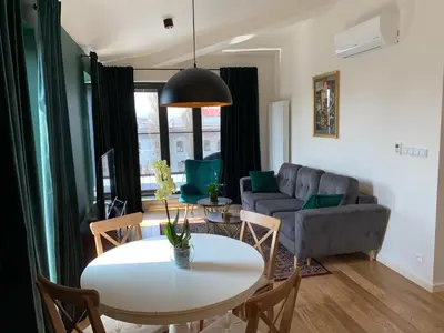 a living room with a table and a couch at AGIHOME Rajska 3 Apartments in Kraków