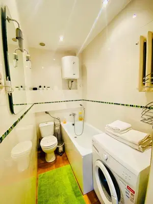 a bathroom with a toilet and a washing machine in it at Apartment in Ivy covered house, near Old Town in Kraków