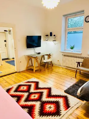a living room with a table and a television at Apartment in Ivy covered house, near Old Town in Kraków