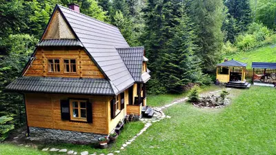 a small wooden house in the middle of a field at DOM NAD POTOKIEM in Zawoja