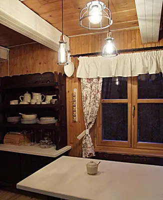 a kitchen with a table and a window and lights at DOM NAD POTOKIEM in Zawoja