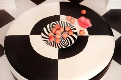 a black and white cake with fruit on a table at Art Apartment in Kraków