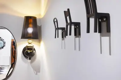 a group of black lights hanging on a wall at Art Apartment in Kraków