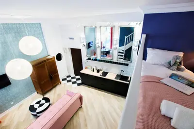 a bedroom with a large bed and a sink at Art Apartment in Kraków