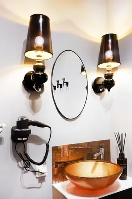 a bathroom with two lights and a sink and a mirror at Art Apartment in Kraków