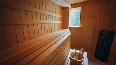 a wooden interior of a sauna with a window at Mountain Cottage Lubomierz in Lubomierz