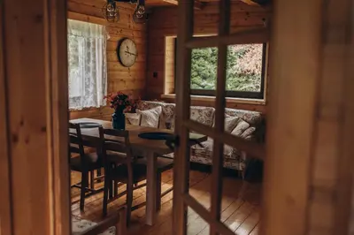 a dining room with a table and a couch at Mountain Cottage Lubomierz in Lubomierz