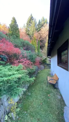 a bench sitting in the grass next to a building at Mountain Cottage Lubomierz in Lubomierz