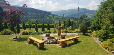 a park with benches and a fire place in the grass at Zawoja hrabkowa Jastrzębowka in Zawoja