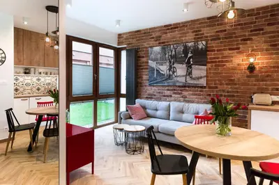 a living room with a couch and a brick wall at apartamenty Stary Kraków GO in Kraków