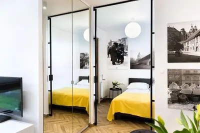 a bedroom with two beds and a mirror wall at apartamenty Stary Kraków GO in Kraków