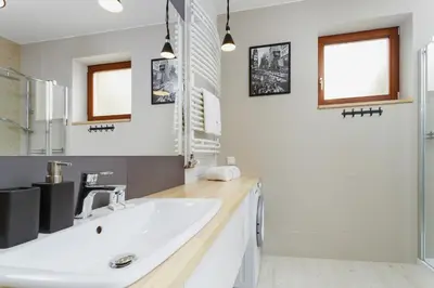 a bathroom with a white sink and a mirror at Apartments Harmonica Trynitarska by Noclegi Renters in Kraków