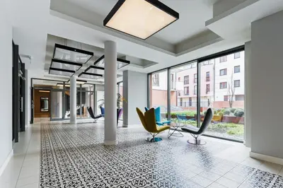 a lobby with chairs and windows in a building at Apartments Harmonica Trynitarska by Noclegi Renters in Kraków