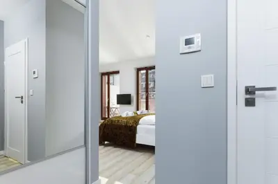 a bedroom with a bed and a mirror at Apartments Harmonica Trynitarska by Noclegi Renters in Kraków