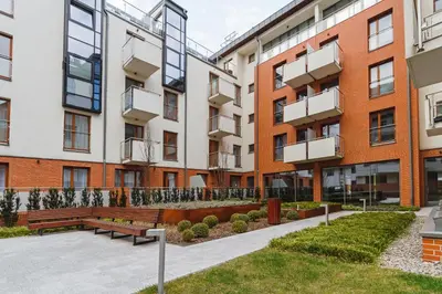 a courtyard in an apartment building with benches at Apartments Harmonica Trynitarska by Noclegi Renters in Kraków