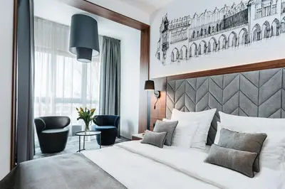 a hotel room with a bed and a chair at Focus Hotel Premium Kraków in Kraków