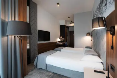 a hotel room with a bed and a tv at Focus Hotel Premium Kraków in Kraków