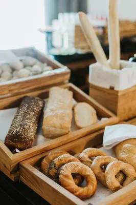 two wooden boxes filled with different types of bread at Focus Hotel Premium Kraków in Kraków