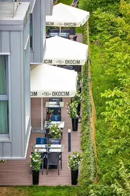 an outdoor deck with tables and chairs on a building at Focus Hotel Premium Kraków in Kraków