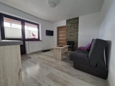 a living room with a couch and a chair at Apartamenty u Krystyny in Klikuszowa