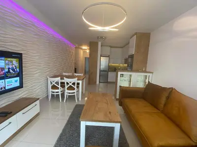 a living room with a couch and a tv and a table at Apartament VIP in Kraków