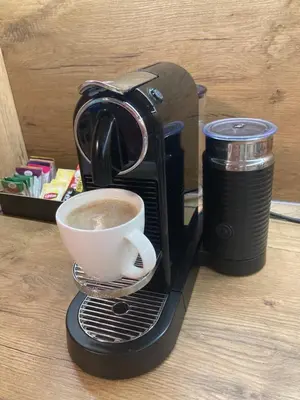 a coffee maker with a cup of coffee on a plate at Apartament VIP in Kraków