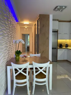 a kitchen and dining room with a wooden table and chairs at Apartament VIP in Kraków