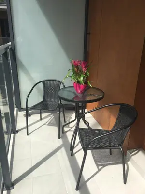 three chairs and a table with a plant on a balcony at Apartament VIP in Kraków