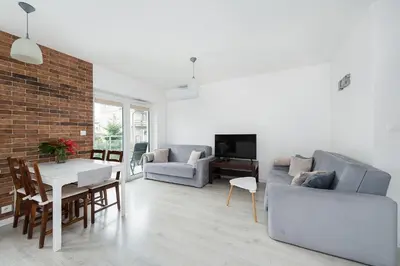 a living room with a couch and a dining room at Bella Casa Premium Apartment - 104 Kobierzynska in Kraków