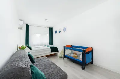 a bedroom with a baby crib and a bed at Bella Casa Premium Apartment - 104 Kobierzynska in Kraków
