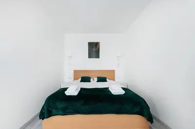a bedroom with a bed with a green blanket at Bella Casa Premium Apartment - 117A Kobierzynska in Kraków