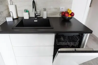 a kitchen counter with a sink and a bowl of apples at Bella Casa Premium Apartment - 117A Kobierzynska in Kraków