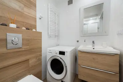 a bathroom with a washing machine and a sink at Bella Casa Premium Apartment - 117A Kobierzynska in Kraków