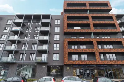 an apartment building with cars parked in front of it at Apartments Kraków Zablocie by Noclegi Renters in Kraków