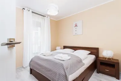 a bedroom with a bed with two towels on it at Apartments Kraków Zablocie by Noclegi Renters in Kraków